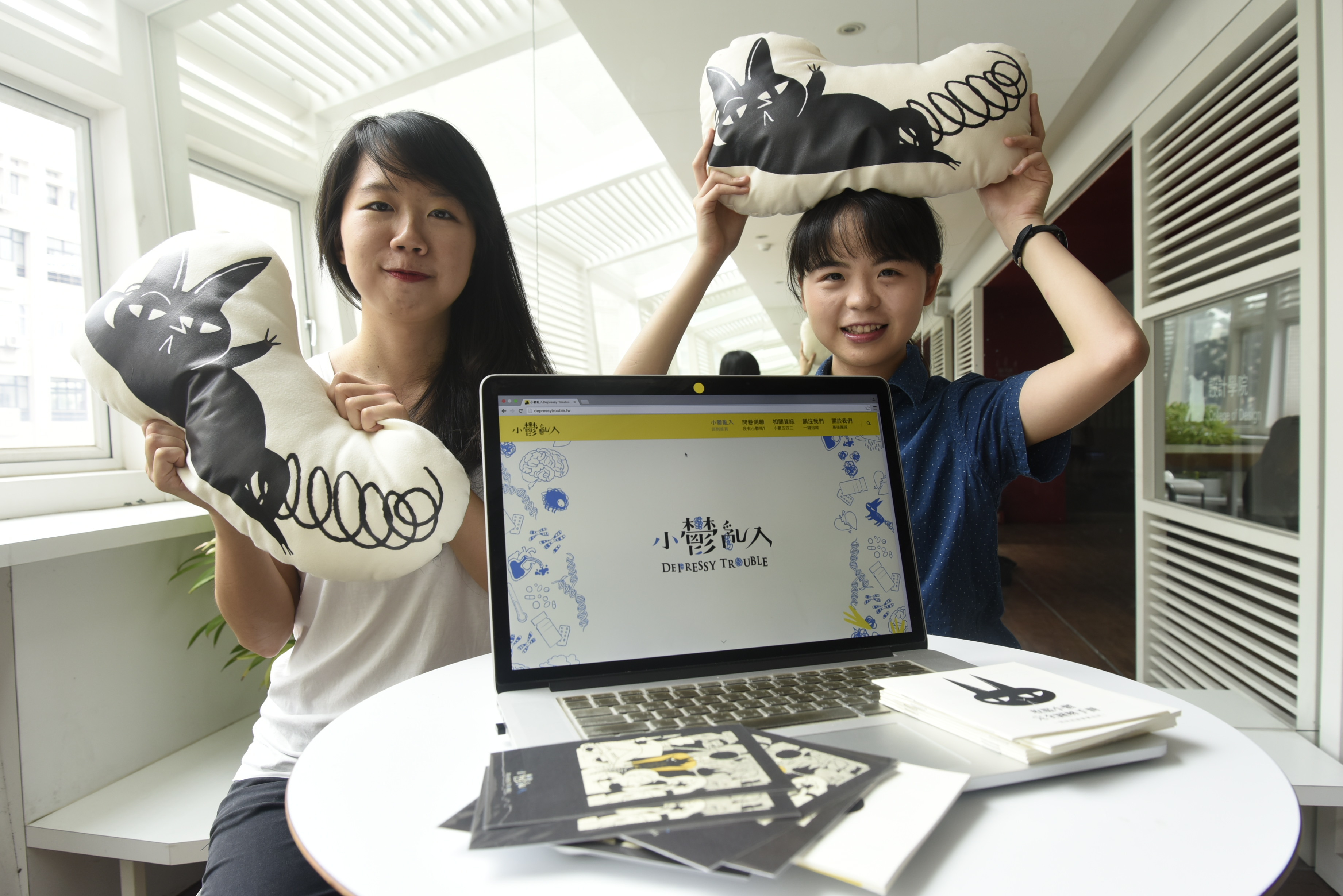 Lin Bai (right) and Yu-Heng Lin (left), alumni of the Department of Design at Taiwan Tech, chose depression as the theme of their graduation project. They created the cute yet mysterious black creature “Depressy” and established an information platform on depression services to support people quietly affected by this condition. Photo courtesy of “Little Melancholy Crashes In”; Photography by Hung-Tai Chen.