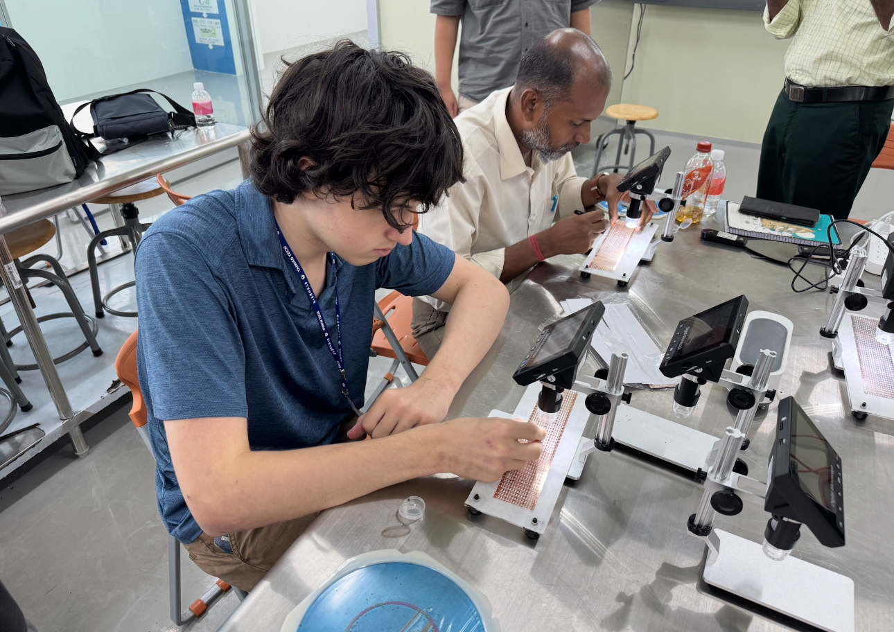 Participant Harry Le Poer Trench applies solder paste to a chip during hands-on practice.