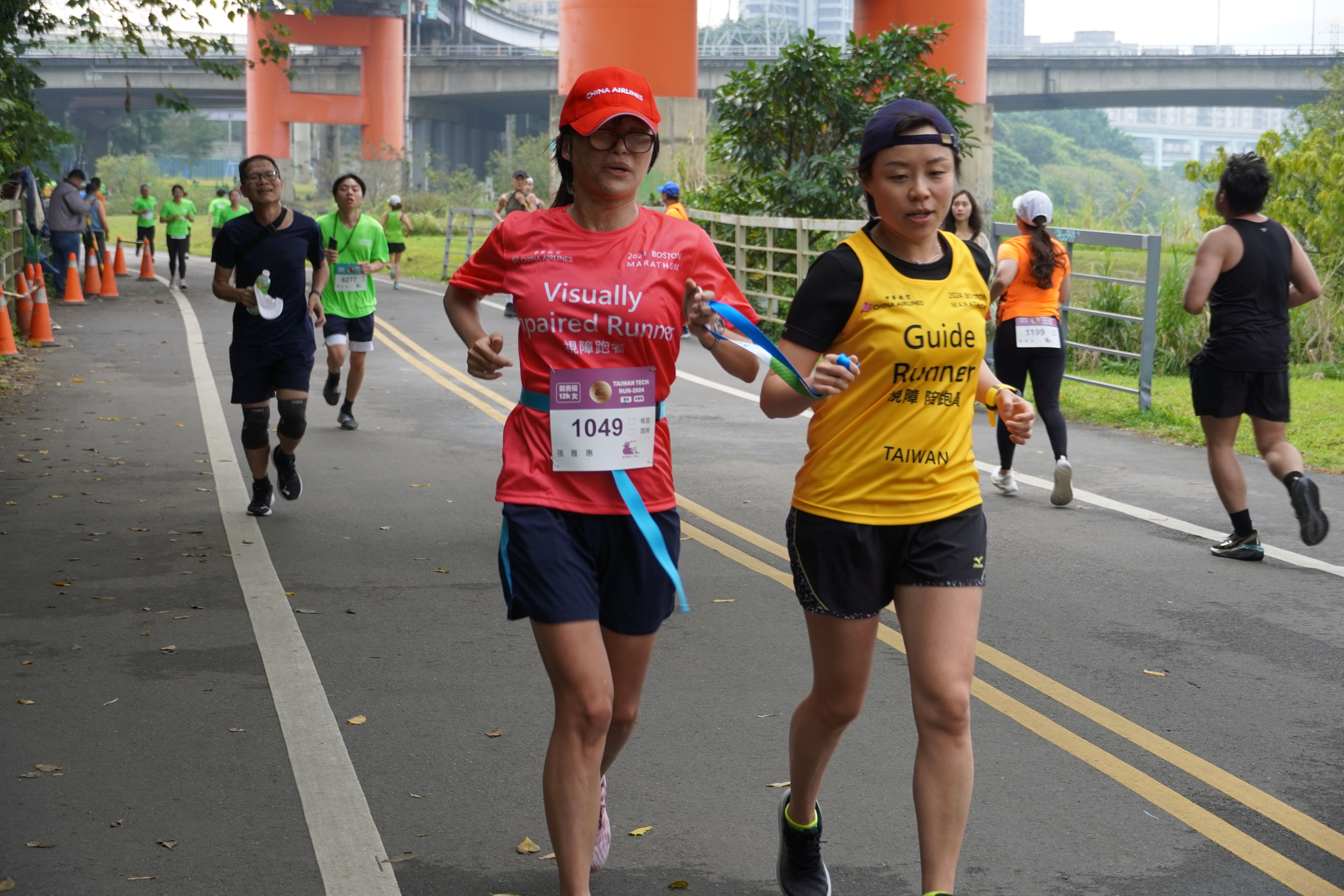Visually impaired runner Ya-Hui Zhang (left) and guide runner Yu-Chun Tsai (right) from the Chinese Blind Running Association successfully completed the 12-kilometer race, showing the spirit of never giving up.