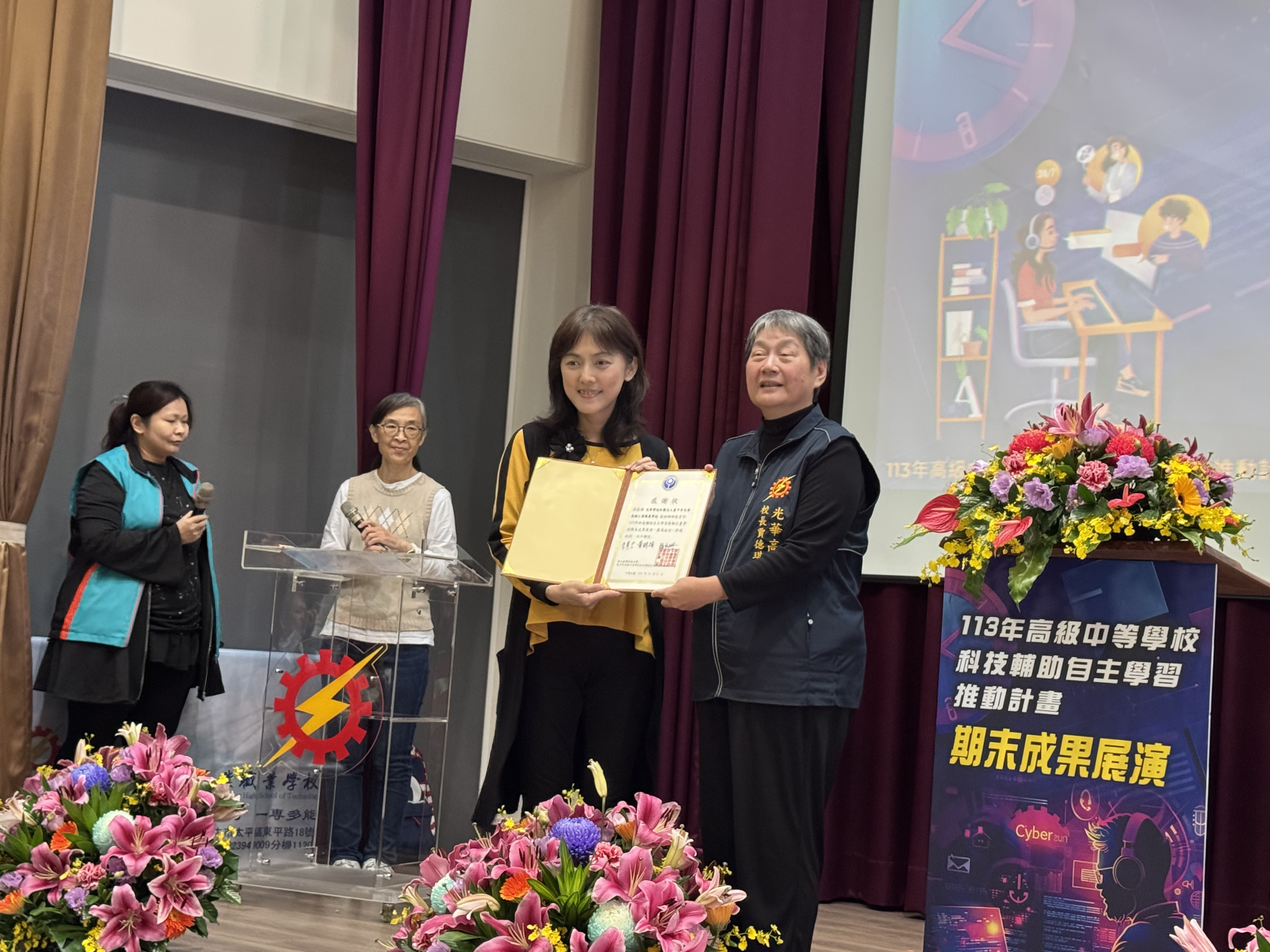 The program’s co-host, Professor Hui-Chun Chu from Soochow University (left), presents a certificate of appreciation to Principal De-Qi Jia of Guanghua Vocational High School (right).
