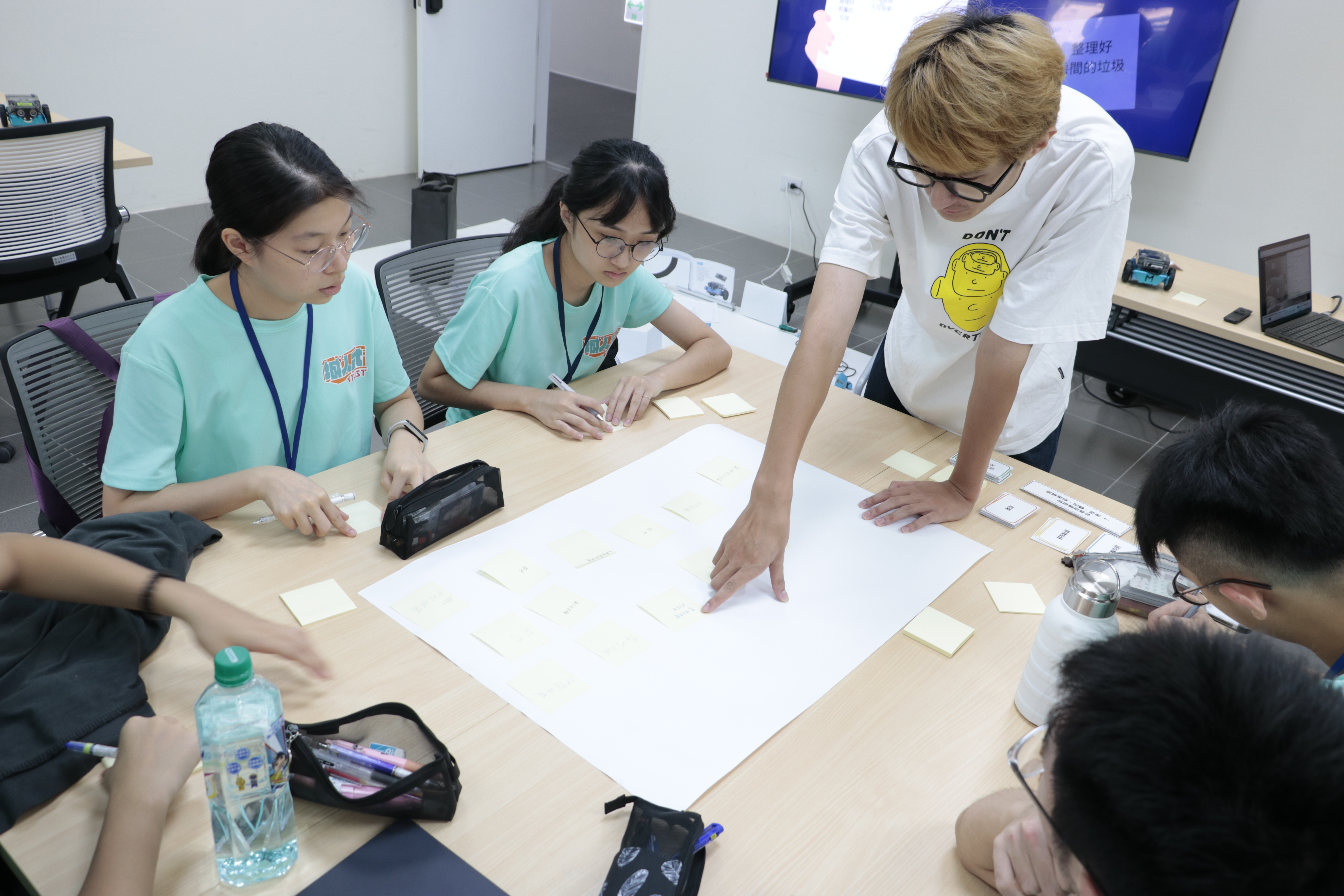 Teaching Assistant Yeh-Kuan Wang guided students in building the basic programming logic for mBots.