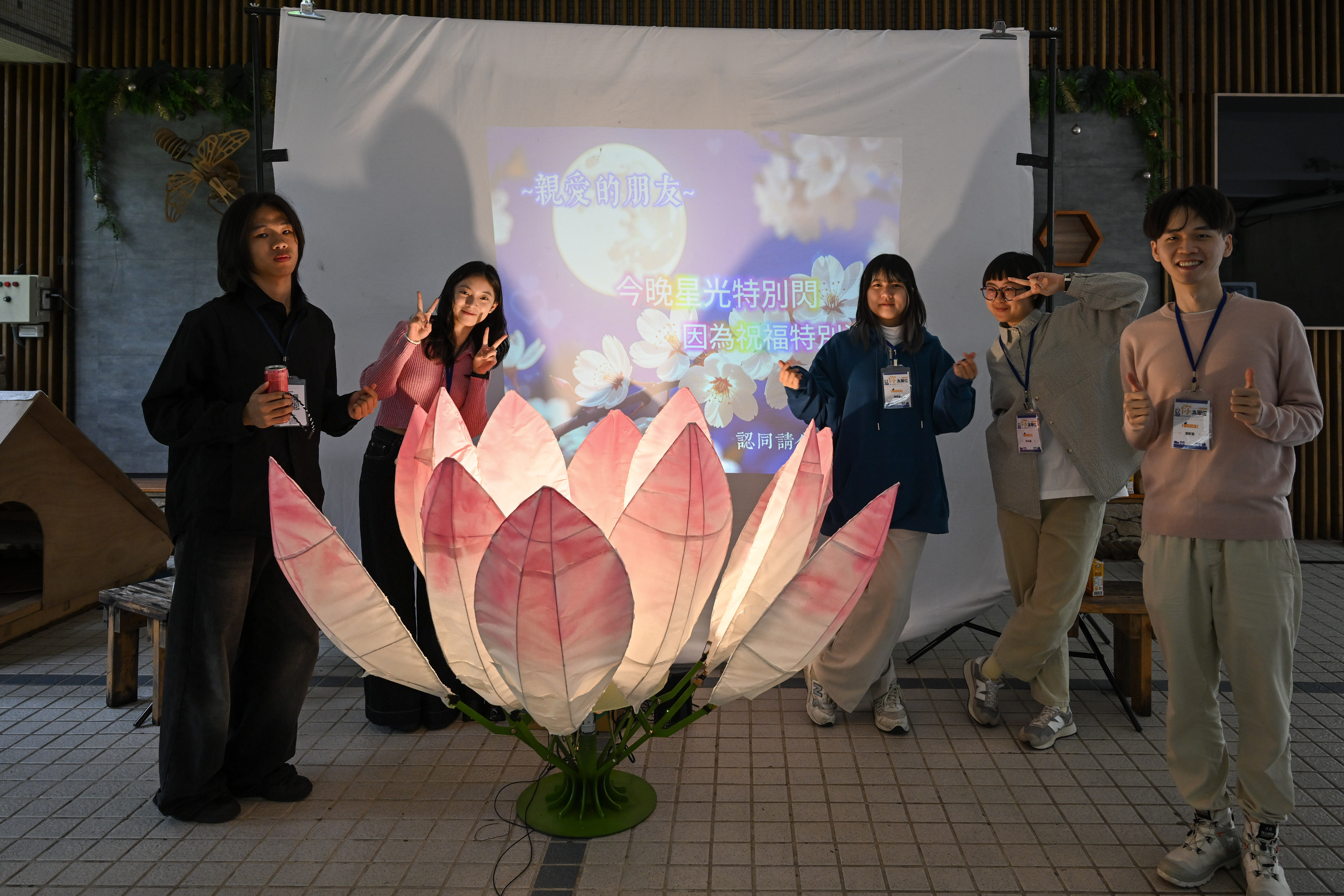 “Lotus Bloom – Wishing You a Wonderful Day” is a mechanical interactive installation shaped like a lotus flower. Pressing a button delivers a warm, caring greeting reminiscent of an elder’s comforting words. The team includes Ting-Hsuan Hsu from the Department of Industrial Management, Hsuan-Hao Liu from the Department of Mechanical Engineering, Wei-Sheng Weng from Electronic and Computer Engineering, and Qiao-Zhen Yang and Ming-Yi Lin from the Business Design Division of the Department of Design.