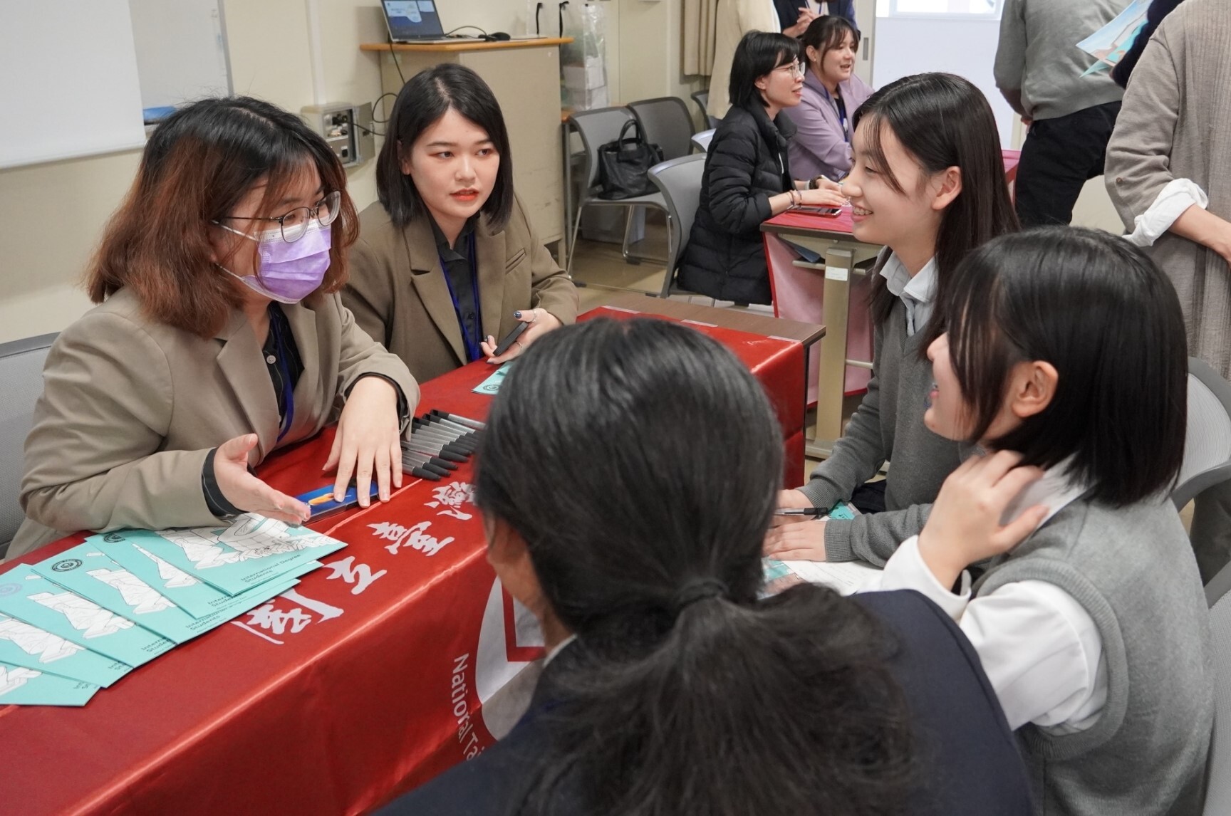 Students from Otokuni High School (right) and Taiwan Tech representatives (left) engage in a detailed discussion about studying in Taiwan.