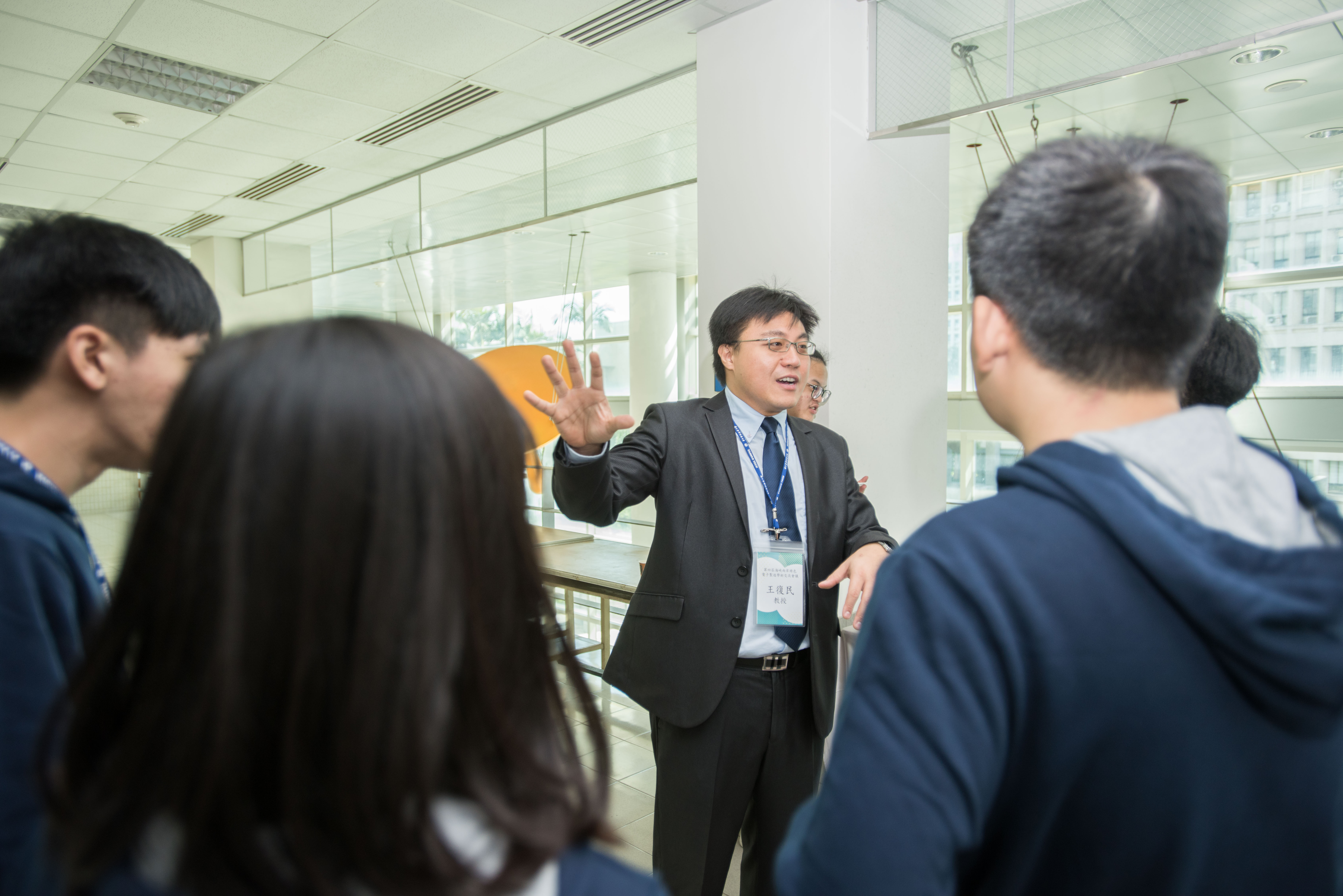 Photo of Distinguished Professor Fu-Min Wang explaining his research findings to conference participants.