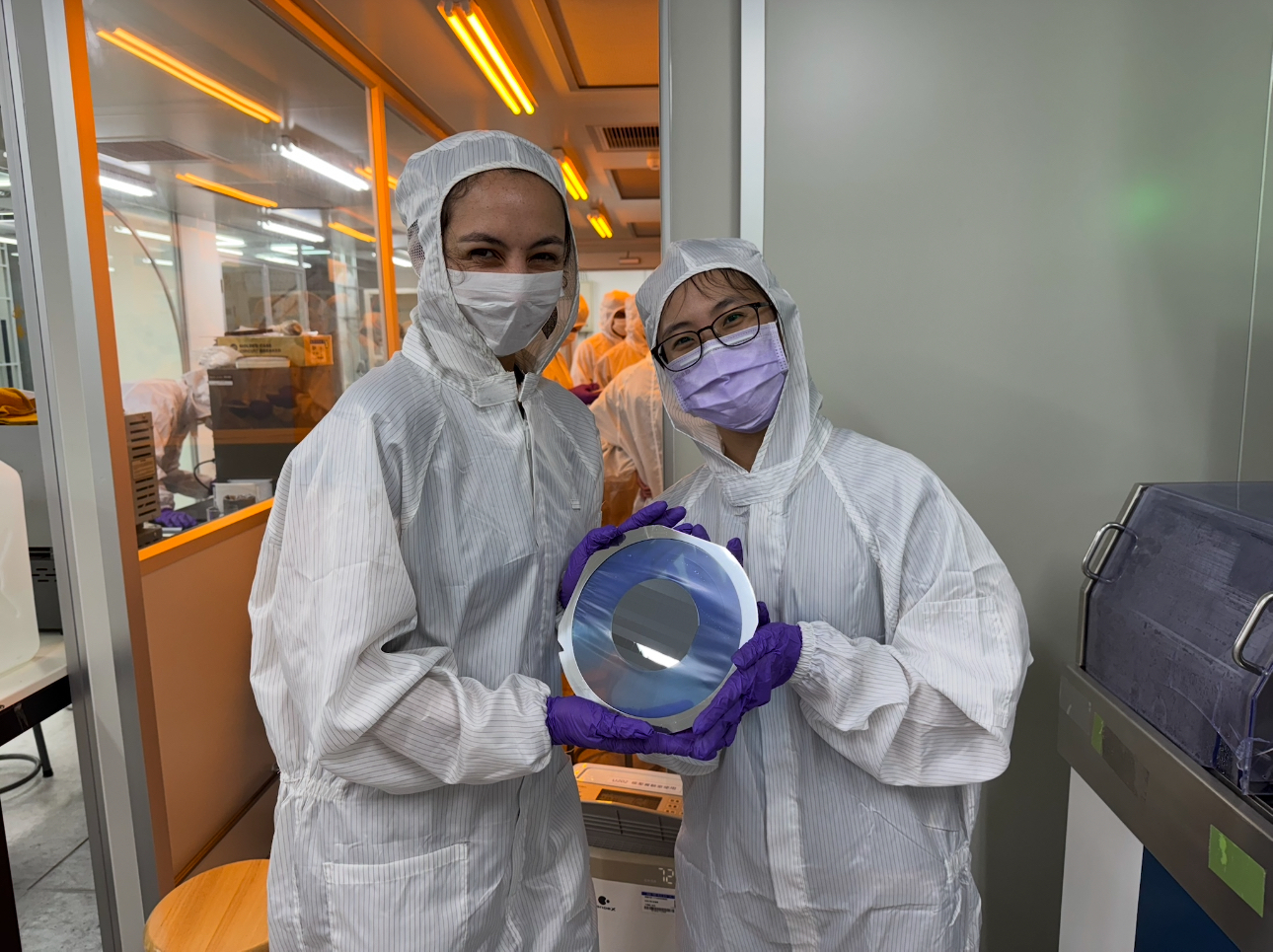 Participant Jaime Pryor (left) and the teaching assistant (right) showcase a wafer after completing the chip dicing process.