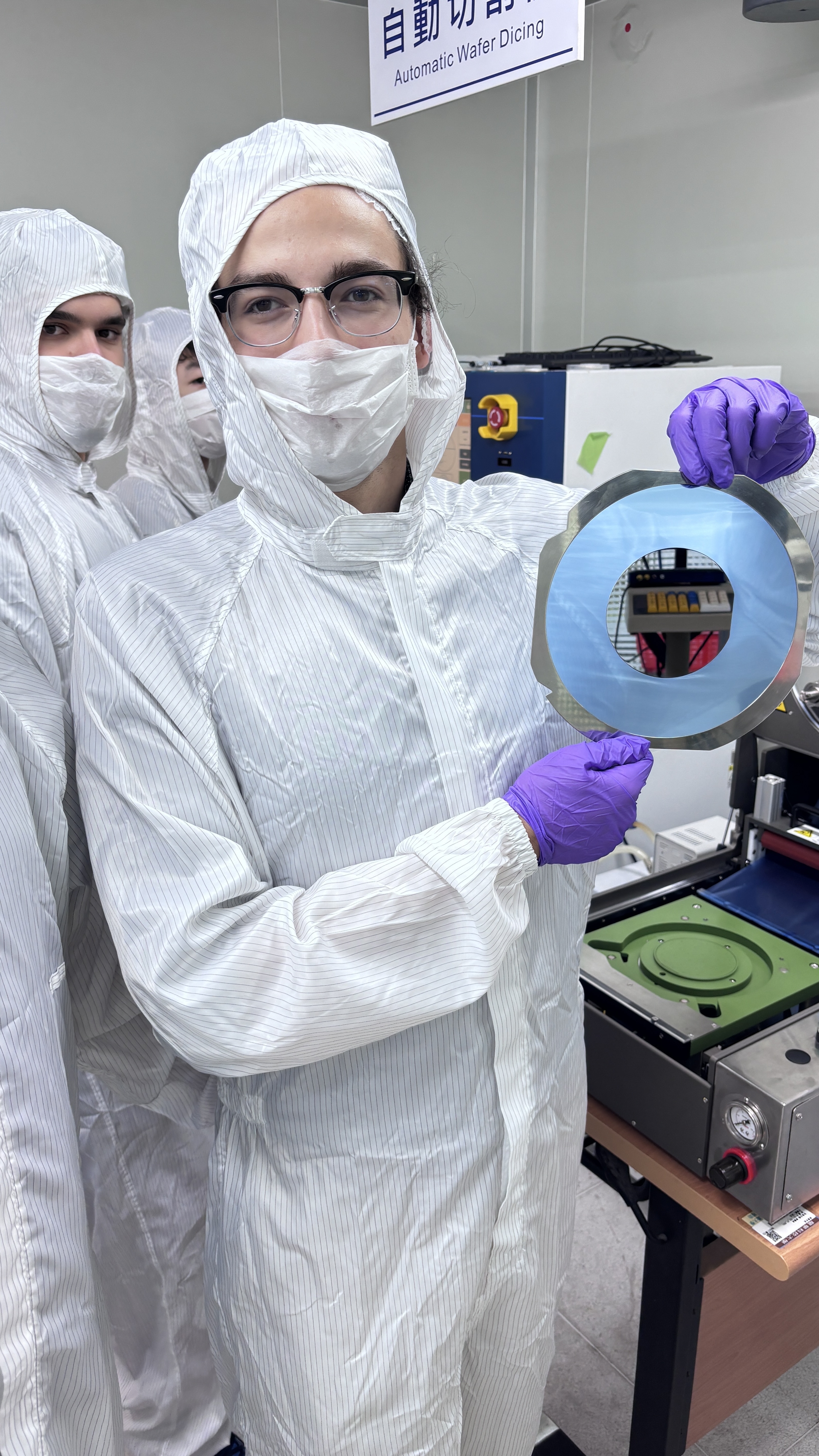 Participant Colin Raimond Zuehlke displays a silicon wafer mounted with adhesive backing.