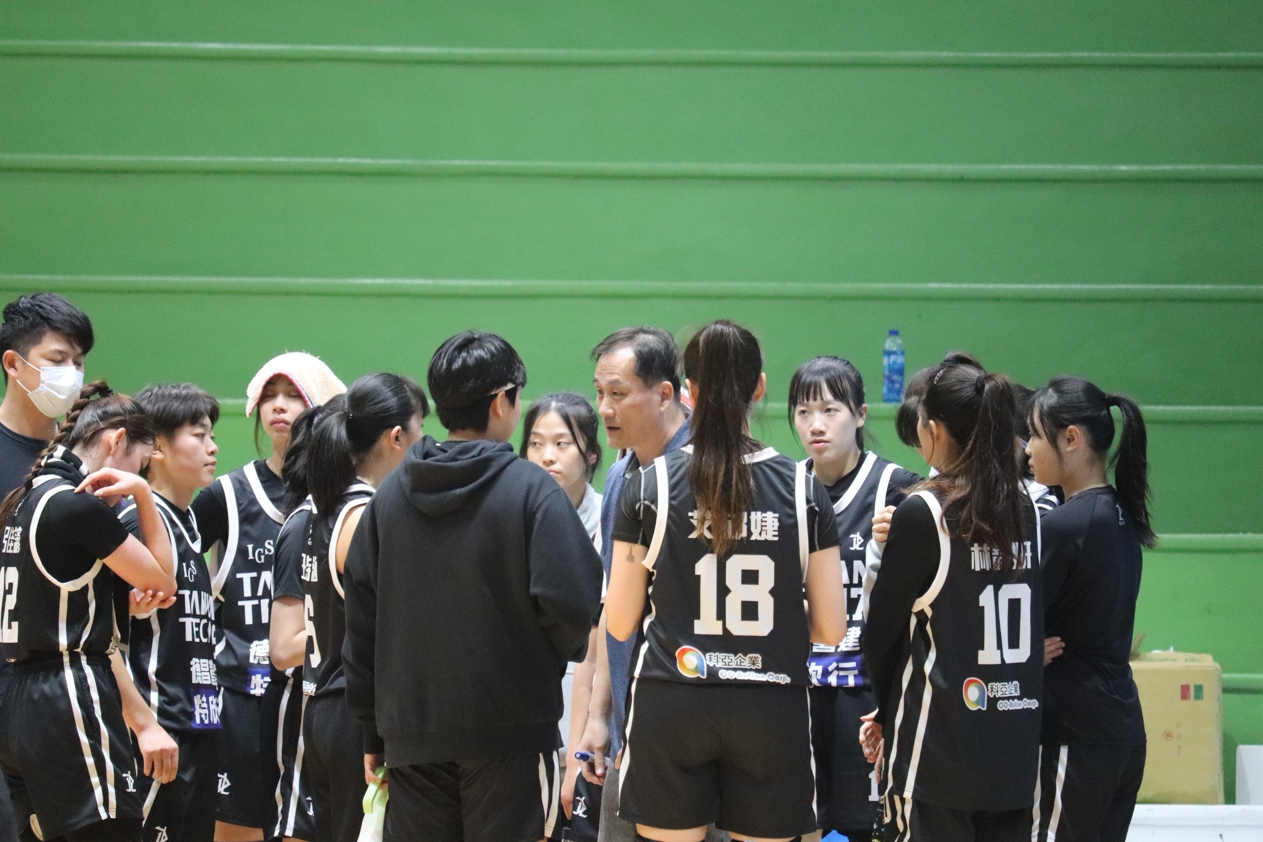 Candid shot of strategy discussion – Women's Open Division, 114th National Intercollegiate Basketball League.